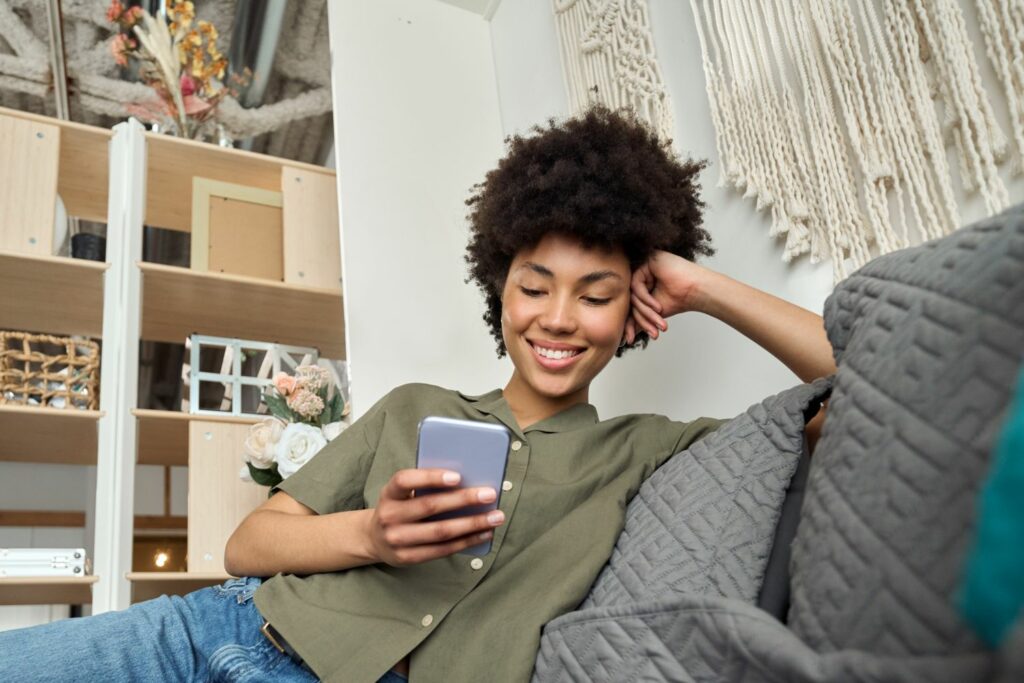 Dating für Akademiker: Frau auf dem Sofa mit Handy